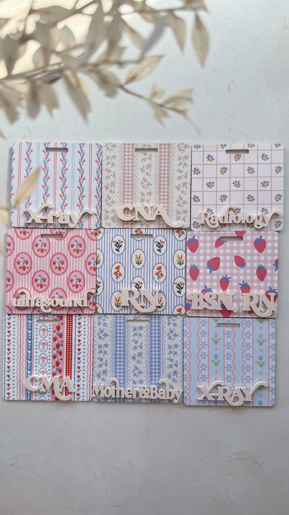 A collection of decorative name badges with floral and fruit patterns. Each badge features a different profession, including , , and , in a wooden font. The badges are in shades of pink, blue, and whi