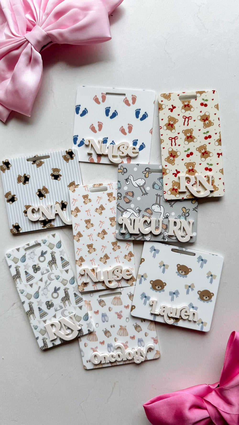 A collection of personalized name badges with various patterns, including teddy bears, footprints, and bows. Some badges have profession titles like "," "," and "." The badges are white with colorful 