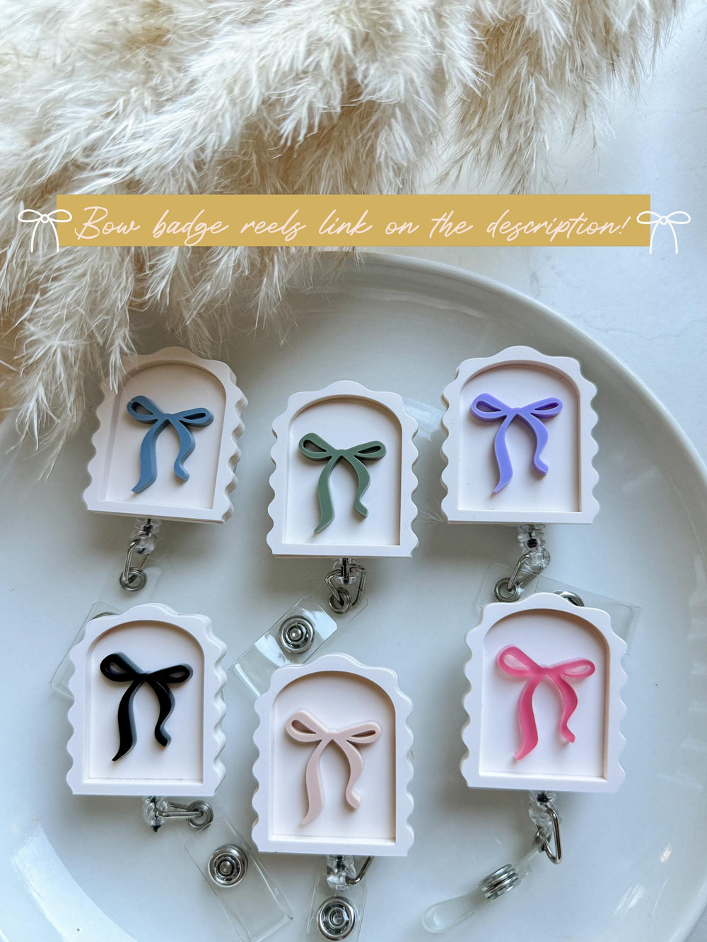 A collection of bow-shaped badge reels in various colors, including blue, green, purple, black, and pink. Each reel features a bow design within a white, arched frame. The text "Bow badge reels link o