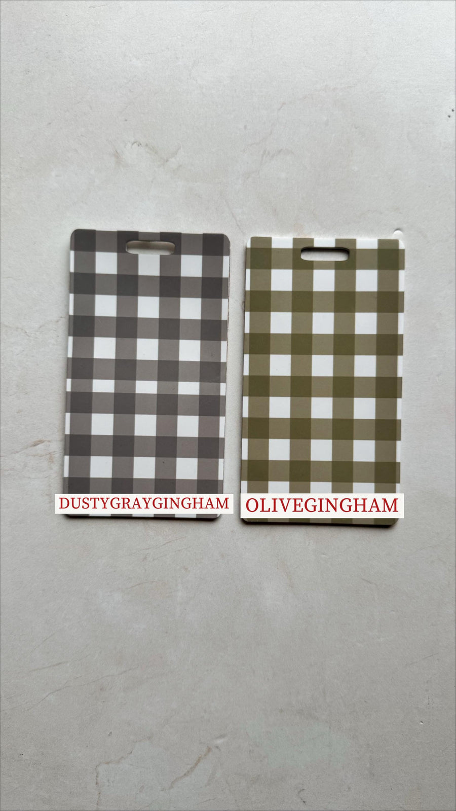 Two rectangular, gingham-patterned items. One is dusty gray and white, the other is olive green and white. Each has a handle cutout at the top. The text "DUSTYGRAYGINGHAM" and "OLIVEGINGHAM" are print