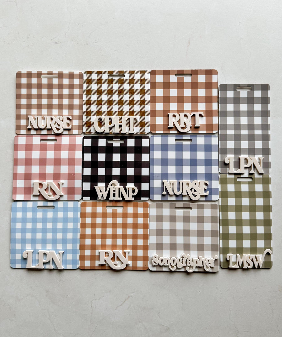 A collection of name badges with a gingham pattern in various colors, including brown, black, red, blue, and gray. Each badge has a cutout for a lanyard and features a profession title in white letter