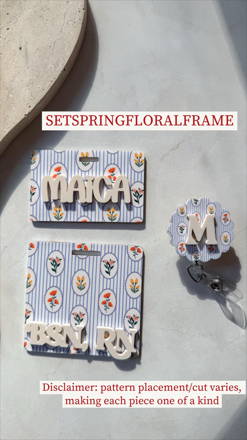 Floral badge reels and name tags with a blue and white striped background and floral accents. One tag says "MAICA", another says "BSN, ", and a badge reel has the letter "M". The text "SETSPRINGFLORAL