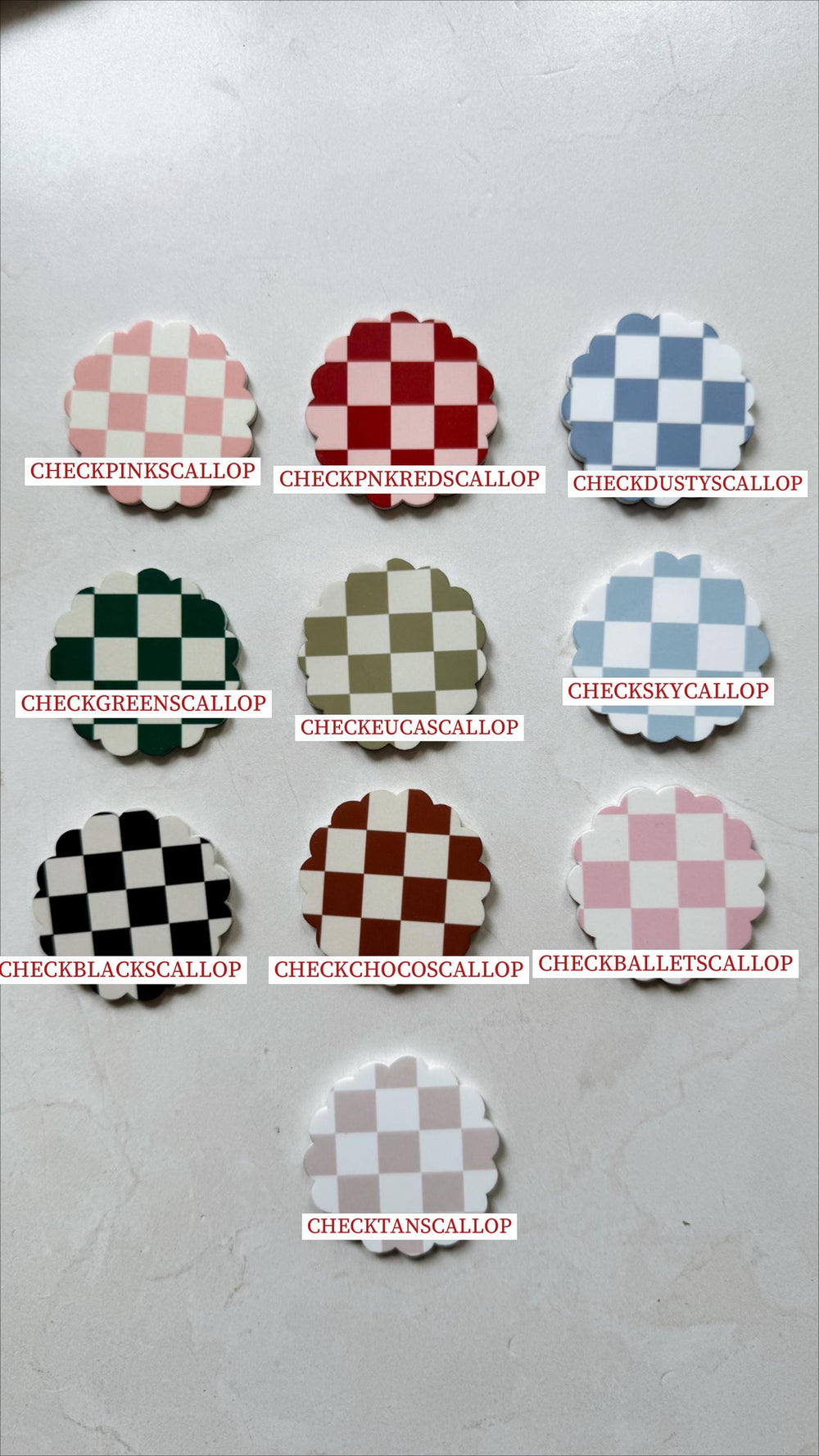 Nine scalloped-edge, checkerboard-patterned decorative pieces in various colors, including pink, red, blue, green, brown, black, and tan. Each piece has a unique color combination and a corresponding 