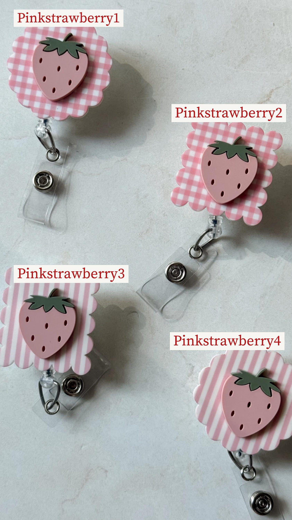 Four pink strawberry-themed badge reels. Each reel features a pink strawberry design with a green stem. The background patterns vary, including gingham and stripes. The text "Pinkstrawberry1", "Pinkst