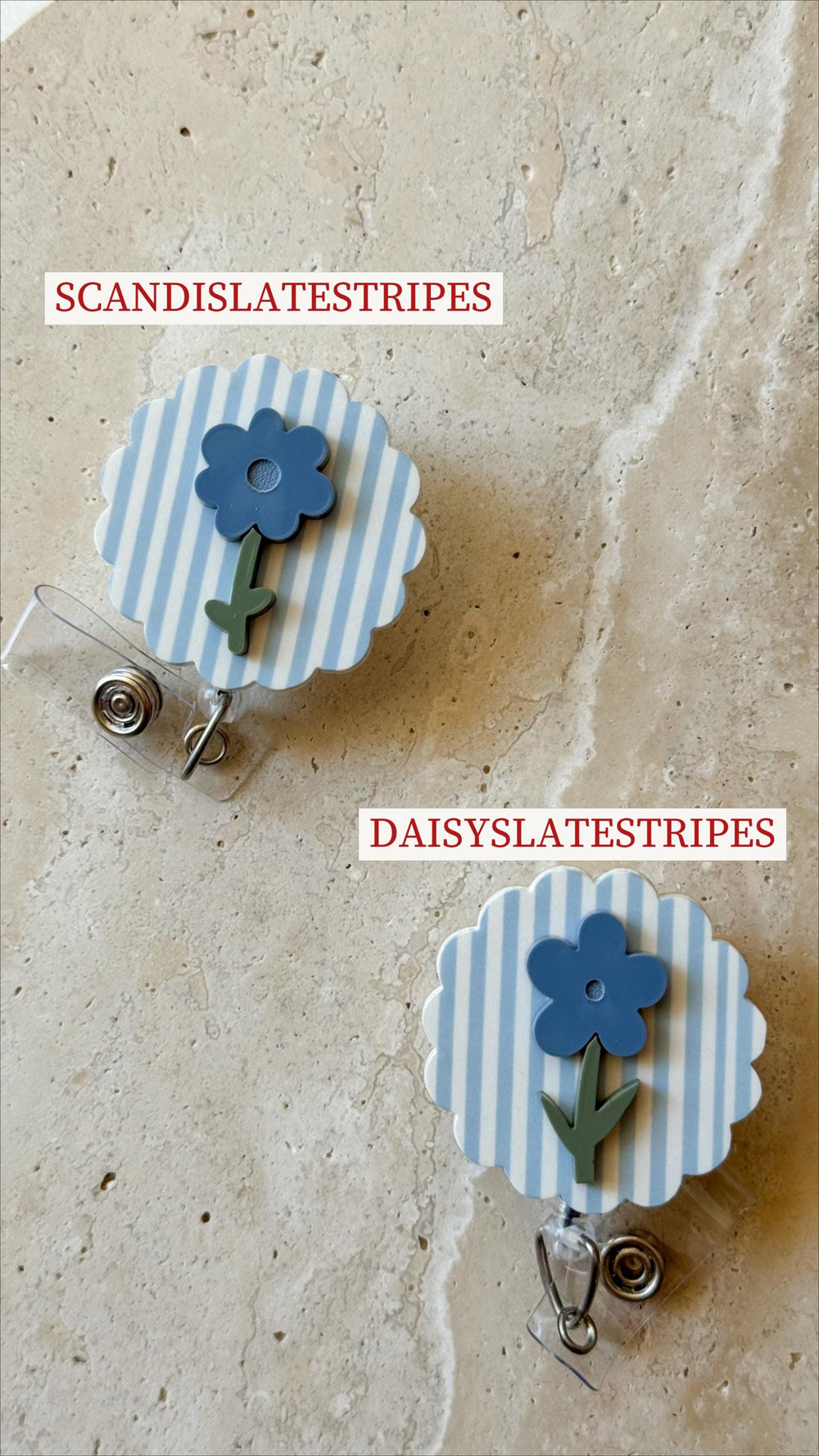 Two flower-shaped badge reels. Each reel has a blue and white striped background with a blue flower and green stem. The text "SCANDISLATESTRIPES" and "DAISYSLATESTRIPES" are visible.