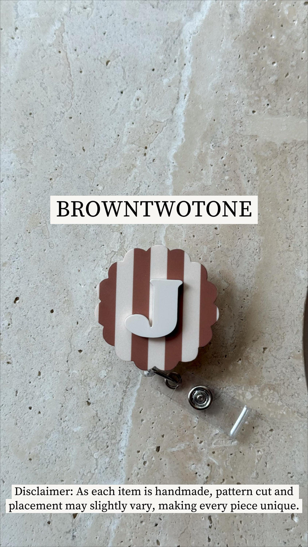 A badge reel with a brown and white striped design and a white letter "J". The badge reel has a scalloped edge and the text "BROWNTWOTONE" is above the badge reel.