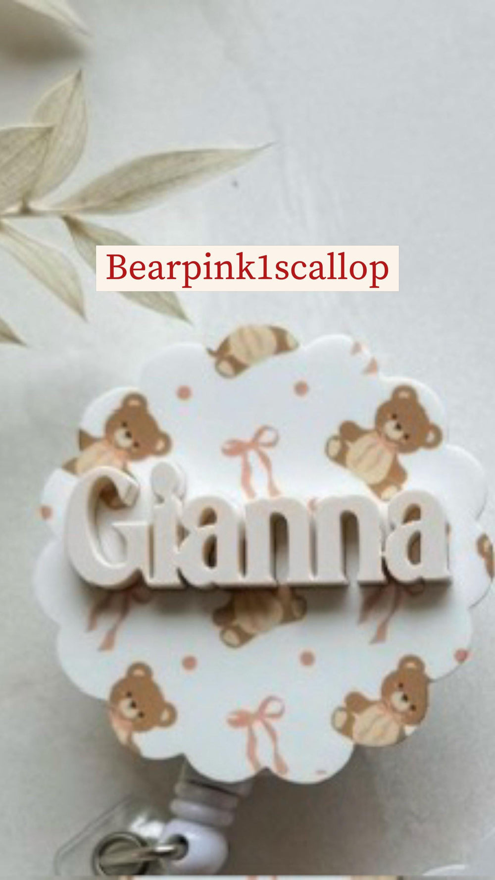 A white badge reel with a scalloped edge, featuring the name "Gianna" in raised letters. The badge has a pattern of brown teddy bears and pink bows. The text "Bearpink1scallop" is at the top.