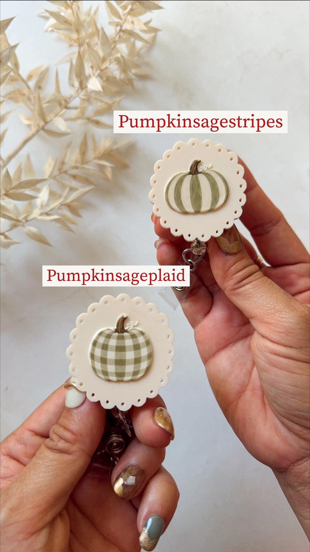 Two round badge reels with scalloped edges and cream-colored bases. One features a sage green striped pumpkin, labeled Pumpkinsagestripes. The other displays a sage green plaid pumpkin, labeled Pumpki